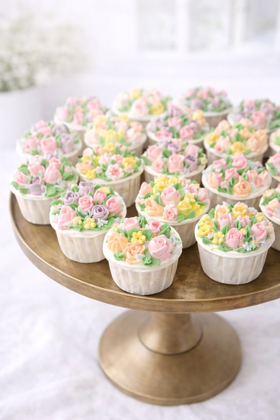 Pastel buttercream bouquet cupcakes on a gold stand