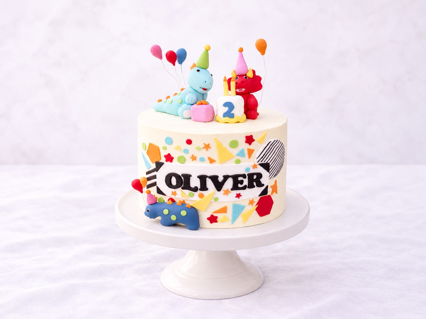 Birthday cake with colourful dinosaur figures and party balloons
